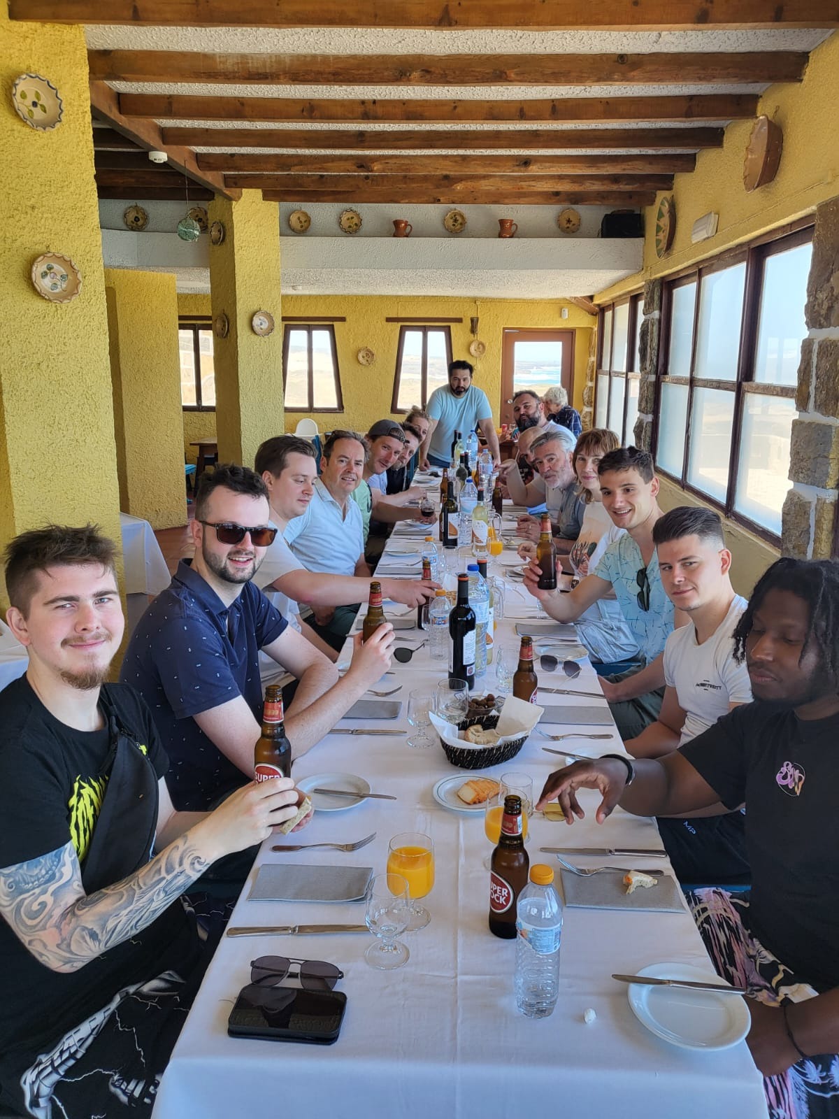 Group enjoying a team dinner at a long table during a Cascais team building retreat