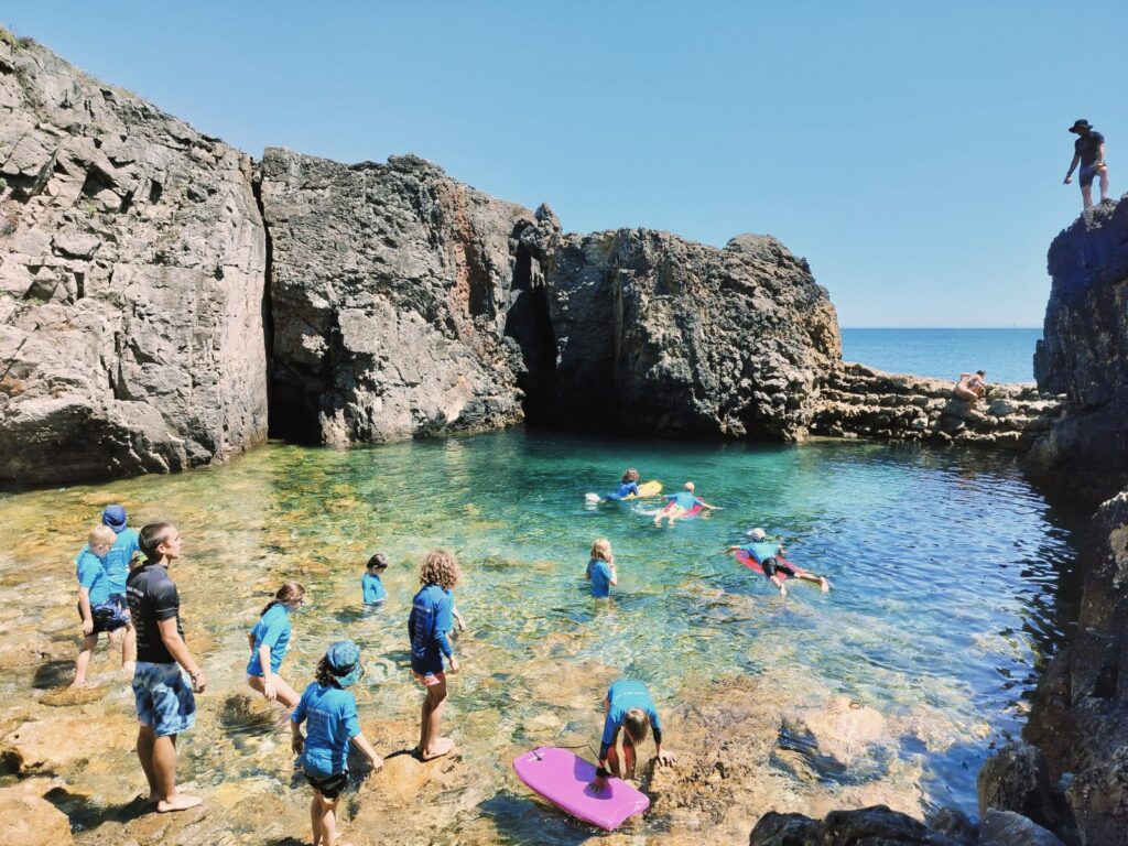 Kids snorkeling and swimming in a rocky cove near Guincho, Cascais