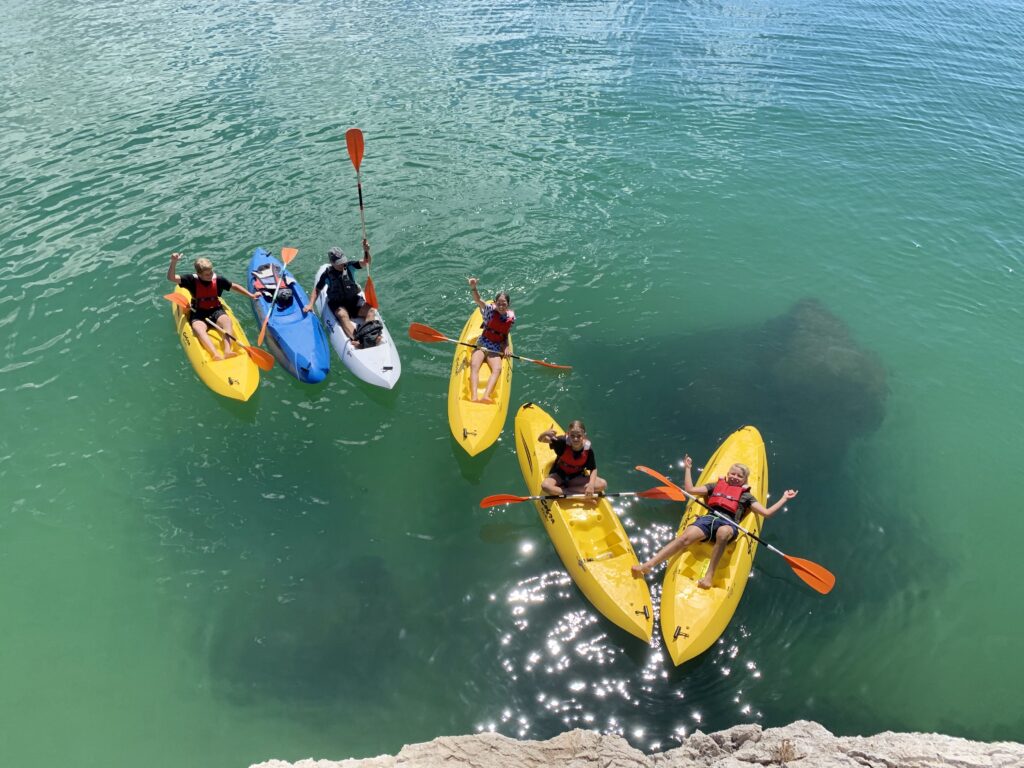 Aerial view of kids kayaking in yellow kayaks during summer camp