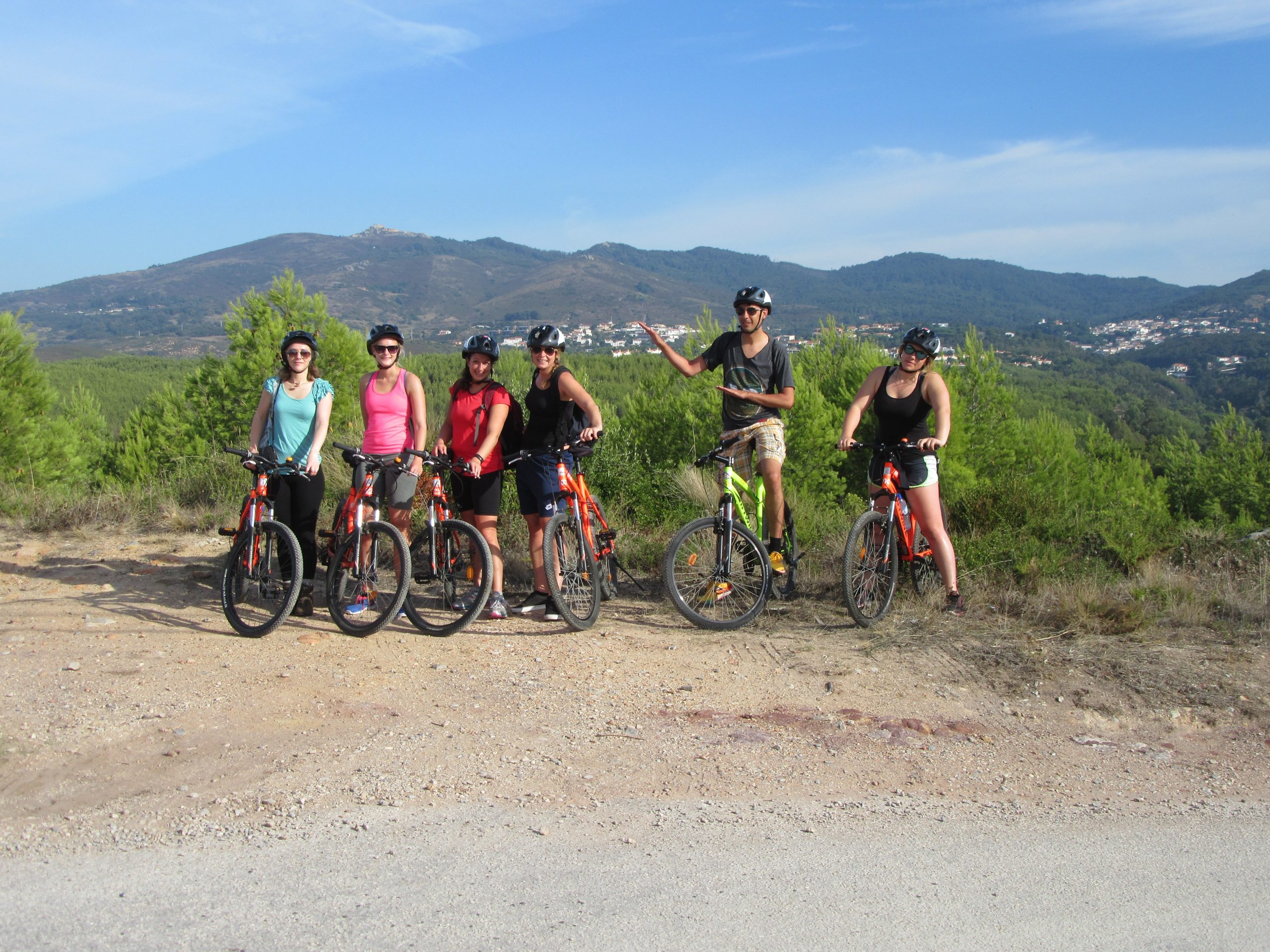 Group of mountain bikers posing on a hilltop trail near Sintra