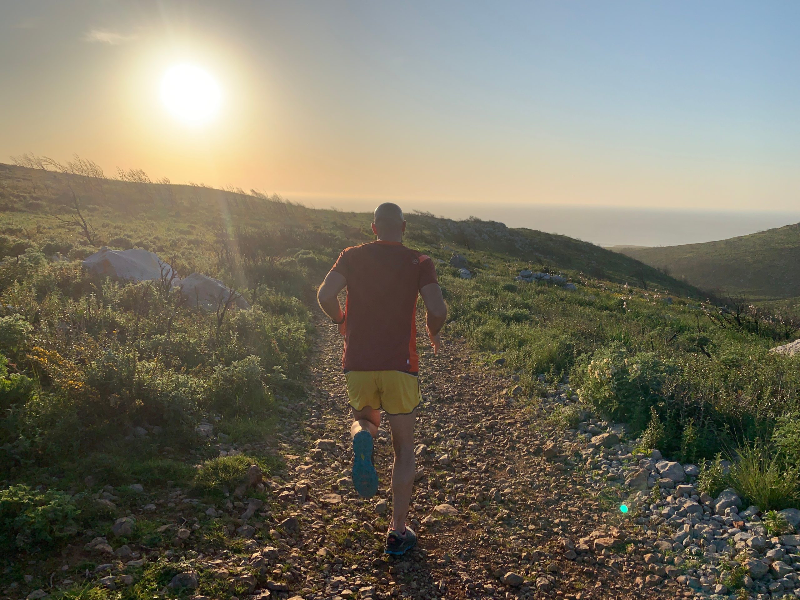 Trail runner on a coastal cliff path at sunrise, Cascais