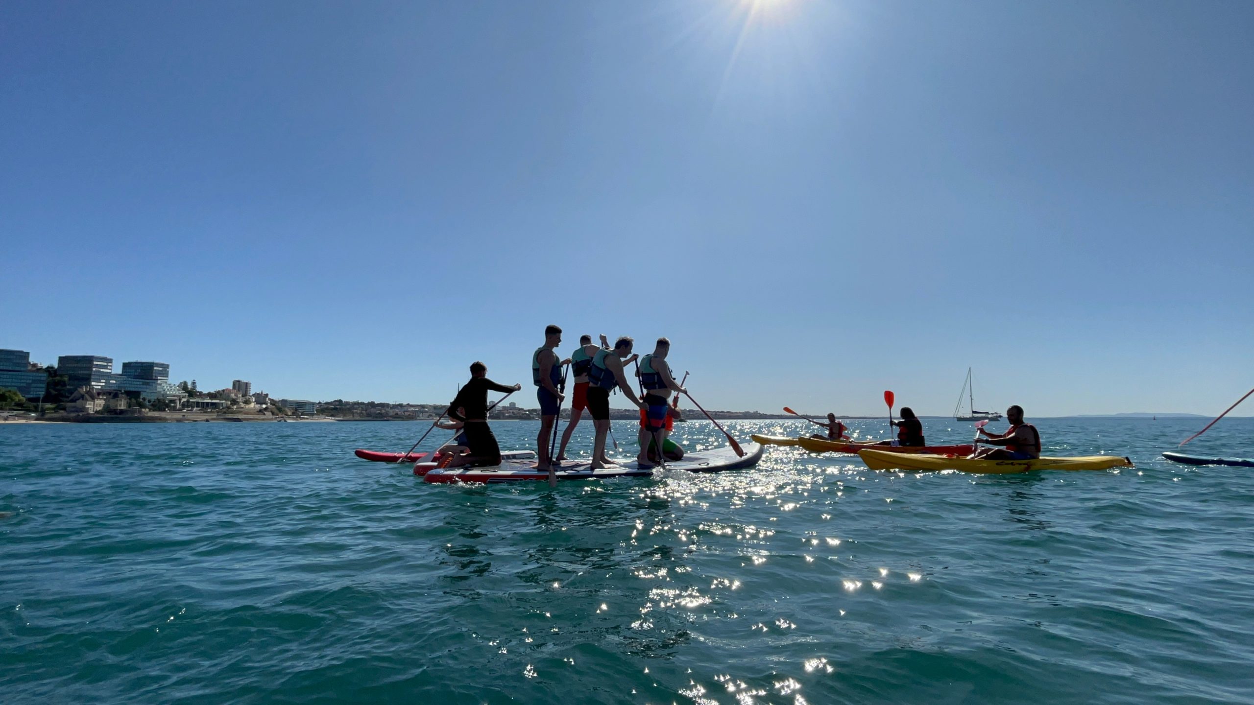 Group standing together on a giant SUP board near Cascais marina