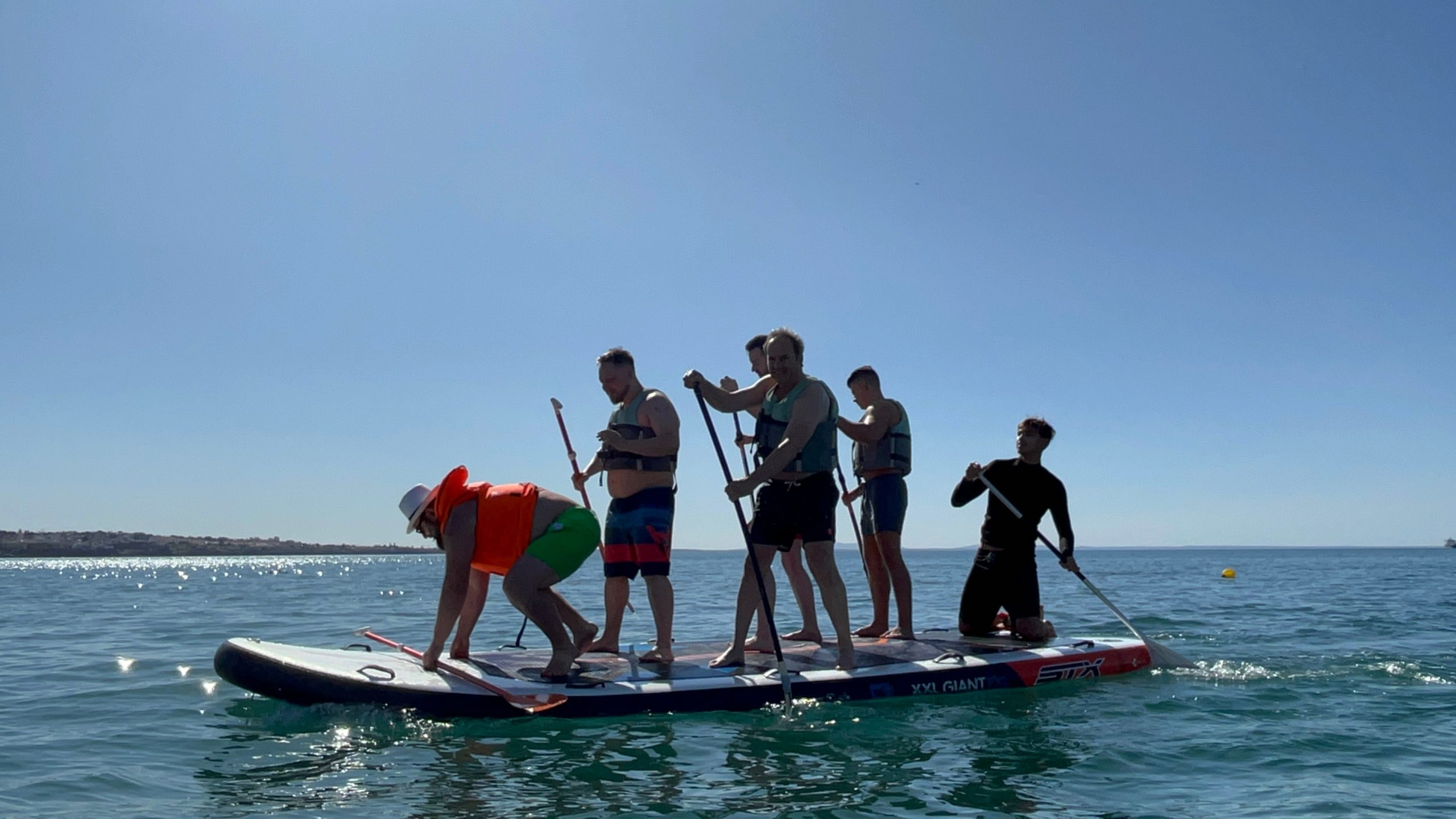 Group paddleboarding together on an XXL SUP board, Cascais