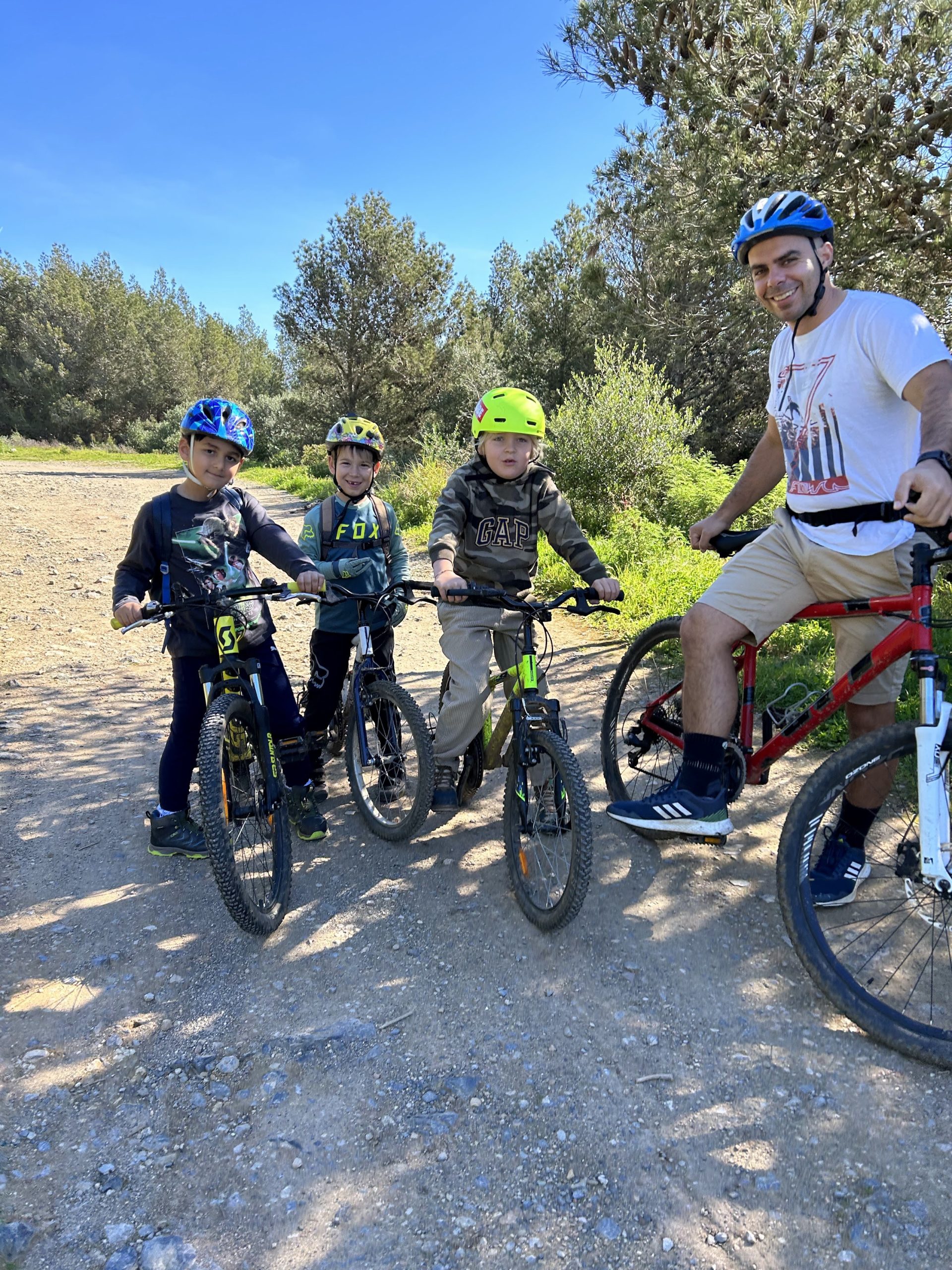 Father and three kids on mountain bikes on a forest trail